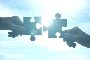 Hands putting puzzle pieces together